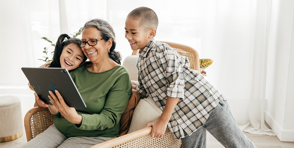 Grandmother and grandchildren looking at tablet